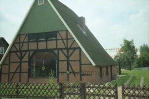 Pöhlser Weg 7: Fachwerkkate: Teilansicht: giebelständige Straßenfront mit ehemaligem Scheunentor