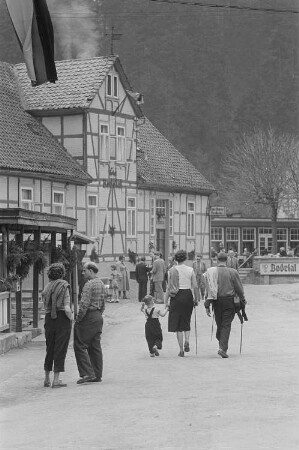 Straßenszene mit Urlaubern im Bodetal, links das Hotel Bodetal