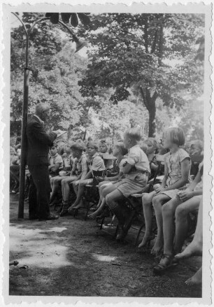 Der Autor und Fabeldichter Rudolf Kirsten liest vor Kindern in einem Park