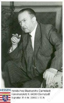 Zinnkann, Heinrich (1885-1973) / Porträt, eine Zigarre rauchend, sitzend, Kniestück