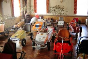 Seifenkisten im Saal der Gastwirtschaft, eine ständige Ausstellung; beim Dorf fand das 1. Thüringer Seifenkistenrennen statt