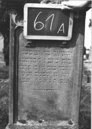 Grabstein 61 (Index: 100114035) Material: Sandstein Zustand: verwittert Maße HxBxT: 120x52x19 cm Beschreibung: Stele, Sockel, eingezogener Rundbogenabschluß mit Verdachung und Eckakroteren, Schriftfeld mit drei Rundbögen Symbolik: Blüten, stilisierte Blätter: Grabstein 61A