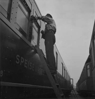 Anhalter Bahnhof. Wagenreiniger bei der Arbeit auf der Leiter an einem Mitropa-Speisewagen : Berlin-Kreuzberg. Anhalter Bahnhof. Wagenreiniger bei der Arbeit auf der Leiter an einem Mitropa-Speisewagen