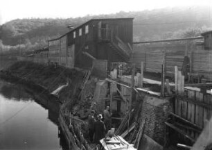 Roßwein. Sächsische Patentachsenfabrik Kadner & Co. Bau der betriebseigenen Brücke über die Mulde von der Wehrstraße zur Uferstraße. Bau der Uferbefestigung. Ansicht von der Mulde auf die Baustelle und ein Werksgebäude