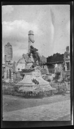 Saint-Mihiel (Dep. Meuse, Frankreich): "Kriegerdenkmal" mit einem darauf dargestellten fallenden Soldaten mit Feldtrompete in der Hand, dahinter Gebäuderuinen