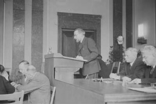 Beratung des Sächsischen Landtages : Sitzung des Sächsischen Landtags, Soldatenheim Dresden. Am Rednerpult Wilhelm Koenen, rechts daneben Rudolf Friedrichs und Kurt Fischer
