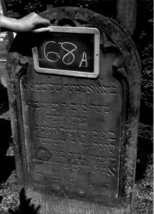 Grabstein 68 (Index: 100109959) Material: Sandstein Zustand: leicht verwittert Maße HxBxT: 132x53x20 cm Beschreibung: Stele, Sockel, Rundbogenabschluß, Schriftfeld eingetieft mit Rundbogenfries Symbolik: Rundbogenfries: Grabstein 68A