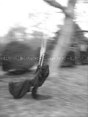Schwarz verhüllte Person auf einer Schaukel (Sonderthema: Wunderland) (Altersgruppe SCH)