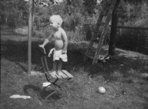 Kleiner Junge auf einem Gartenstuhl