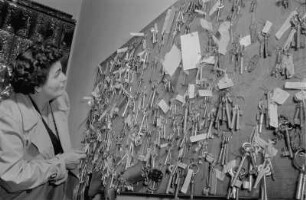 Fundbüro. Frau, die Schlüsselsammlung durchsehend