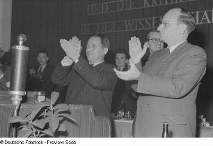 Portrait von applaudierenden Männern hinter einem Rednerpult