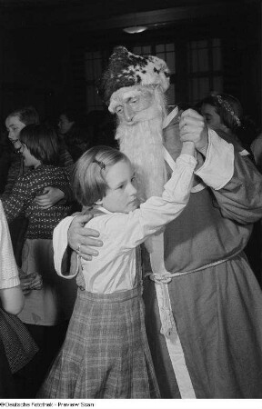 Der Weihnachtsmann tanzt mit einem Mädchen auf der Weihnachtsfeier der Pioniere der 28. und 40. Grundschule