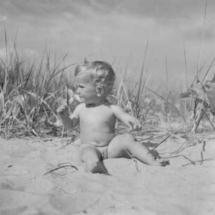 Kleinkind sitzt am Strand