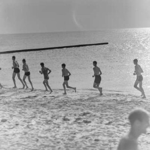 Jugendliche laufen am Strand entlang