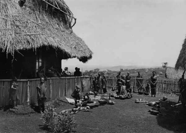 Hommes et femmes en mission avec des objets ethnographiques.