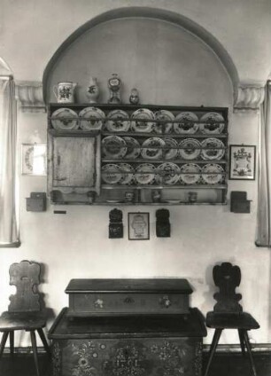 Dresden. Museum für Sächsische Volkskunst mit Puppentheatersammlung. Obergeschosswand mit Steinkonsolen und eingewölbten Blenden. Tellerbrett mit Steinguttellern, Bauernstühlen und Truhe