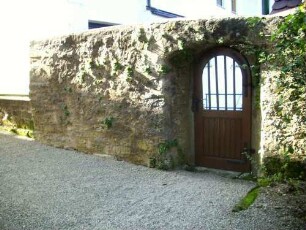 Kirchhof im Norden-Kirchhofmauer mit neuzeitlicher Pforte (Wehrgang mit Steinbrüstung im 19 Jh abgetragen) sowie Werksteinen im Mauersteinverband