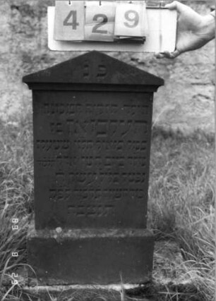 Grabstein 429 (Index: 100107292) Material: roter Sandstein Zustand: gut Maße HxBxT: 81x41x21 cm Beschreibung: Stele, überkragender Giebelabschluß, getreppter Sockel Besonderheit: Kindergrab: Grabstein 429