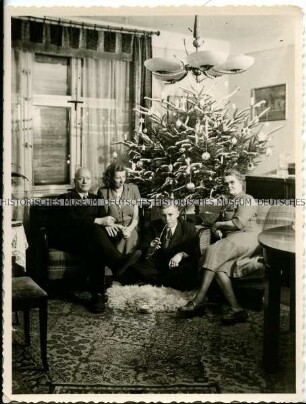 Familie vor dem Weihnachtsbaum