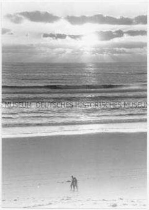 Zwei Menschen gehen am Strand entlang (Altersgruppe 14-17)