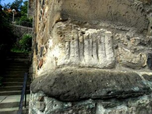 Stadtkirche - Kirchhofmauer im Westen im Querschnitt mit Wetzrillen (symbolische Entschärfung der Dolche vor dem Betreten) sowie Werksteine im Mauersteinverband