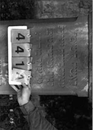 Grabstein 441 (Index: 100107971) Material: roter Sandstein Zustand: versalzen Maße HxBxT: 149x46x27 cm Beschreibung: Stele mit Giebelaufsatz, Seitenkanten stark abgephast, Sockel: Grabstein 441A