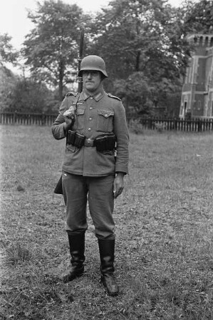 Zweiter Weltkrieg. Niederlande unter deutscher Besatzung. Porträt eines Wehrmachtsangehörigen mit Stahlhelm und Gewehr (wohl bei Den Haag)