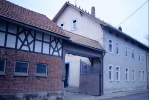 Eingangsbereich eines Gehöftes mit überdachtem Hoftor; Wohnhaus und Nebengebäude