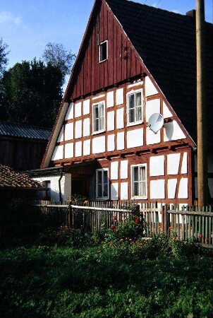 Giebelseite eines Fachwerkhauses und Garten; verbretterte Giebelspitze
