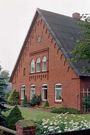 Seefeld 22: traufständiges Bauernhaus aus Backstein: Giebelseite Wohntrakt: oben Feld mit Rundbogenfenstern und Backsteinzier, unter Ortgang steigender Bogenfries, darunter Medaillon mit Jahreszahl 1875: Vorgarten, vorne Gartenzaun