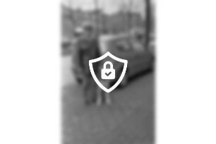 Polizeistation Ahrensburg: Polizeimeisterin [Name maskiert] mit Riesenschnauzer [Name maskiert] Streife: hinten Pkws, Lkws, Bäume und Gebäude: 28. [Name maskiert]