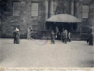 Edinburgh (Schottland). Touristen beobachten vor dem Haupteingang von Holyrood Castle einen Wachsoldaten (wohl bei der Wachablösung)