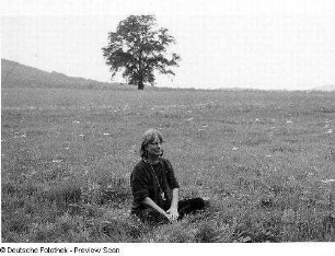 Die Schriftstellerin Elke Erb auf einer Wiese sitzend