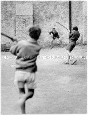 Jungen mit Holzschlägern und einem Ball