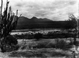 San Antonio-Villamontes mit Pilcomayo und Andenrand : Blick auf eine Siedlung mit Hütten. Im Hintergrund die Anden