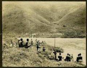 Gruppe von Afrikanern an einem Flussufer