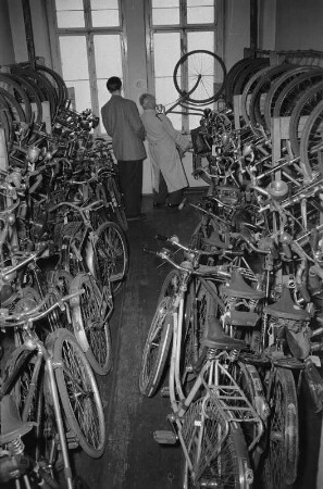 Fundbüro. Angestellter, einem Mann den Fahrradbestand zeigend