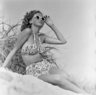 Frau im Bikini mit Sonnenbrille am Strand