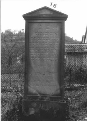 Grabstein 16 (Index: 99804997) Material: Sandstein Zustand: gebrochen und repariert, Stele löst sich vom Sockel Maße HxBxT: 158x60x12 cm Beschreibung: Stele auf Sockel mit abgesetztem Dreiecksgiebel: Grabstein 16