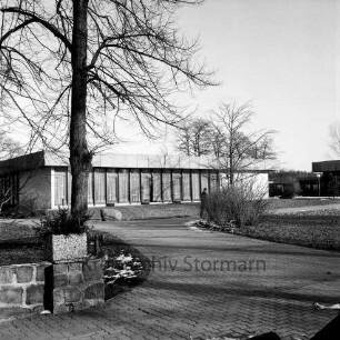 Kloster Nütschau: Speisesaalgebäude: Außenansicht: vorn Auffahrt: links Mauer: dahinter Baum