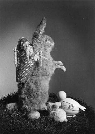 Osterhasenbilder. Sitzender Osterhase mit Kiepe, Vogel und Häschen