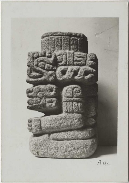 Vue d'une figure accroupie et richement décorée du dieu du vent Quetzalcoatl, associée à des emblèmes du dieu de la pluie Tlaloc. Matériau : Tezontli. Hauteur : 39 cm. (B.T.) (vue latérale)