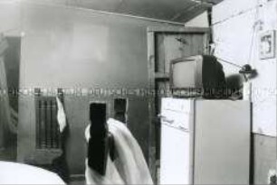 Blick in einen karg eingerichteten Raum mit Fernseher (Sonderthema: Familienbilder)