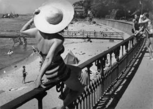 Hamburg-Blankenese. Frau mit Sonnenhut auf einem Geländer am Elbstrand (heute liegt dort das Gelände des Blankeneser Segelclubs)
