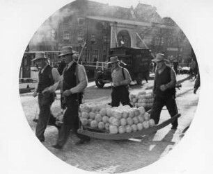 Niederlande. Nordholland. Käsemarkt in Alkmaar. Nach dem Wiegen des Käses auf der Stadtwaage wird er von den Käseträgern der Gilde zum Verladen gebracht.