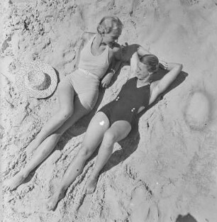 Zwei Frauen in Bademode liegen am Strand