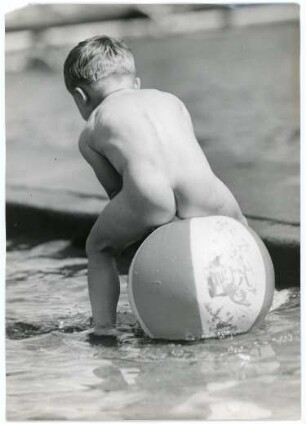 Nackter kleiner Junge auf einem Wasserball