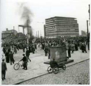 Demonstranten am Potsdamer Platz mit brennendem HO-Kiosk