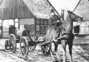 Dörfliche Idylle. Schnapsfass wird mit Pferdewagen transportiert