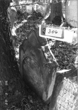 Grabstein 306 (Index: 100115865) Material: Sandstein Zustand: verwittert mit Textverlust, teilweise im Boden versunken Maße HxBxT: 92x61x15 cm Beschreibung: Stele mit giebelartigem Abschluß, eingetieftes Schriftfeld mit Rundbogenabschluß Symbolik: Cohanim-Hände: Grabstein 306